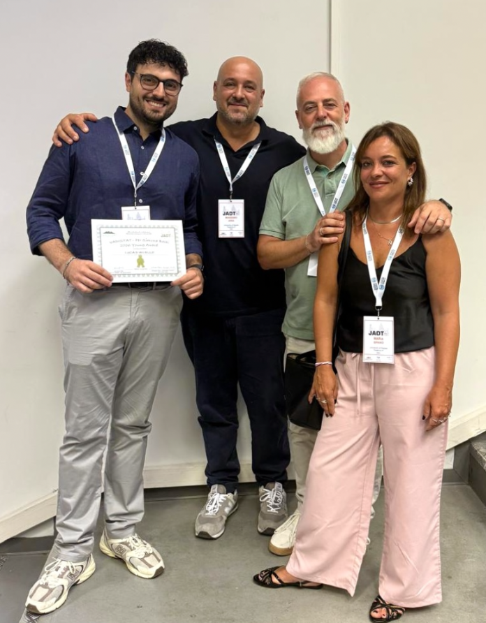 Luca D'Aniello with colleagues at JADT 2026 in Palermo, holding the award certificate